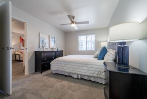 Phoenix apartment for rent - A bedroom with a bed, dresser, and ceiling fan.