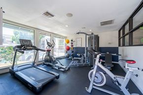 Phoenix apartment for rent - A well-equipped home gym with a treadmill, exercise bike, and other fitness equipment.