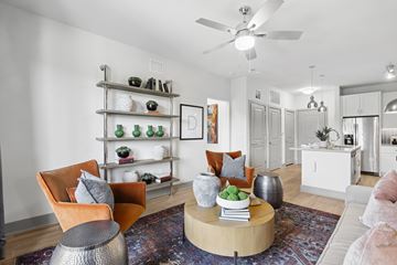 Decatur apartment for rent - A living room with a white ceiling fan and a rug on the floor.