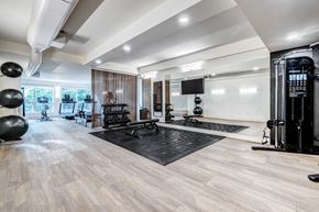 Seattle apartment for rent - a home gym with weights and exercise equipment and a television