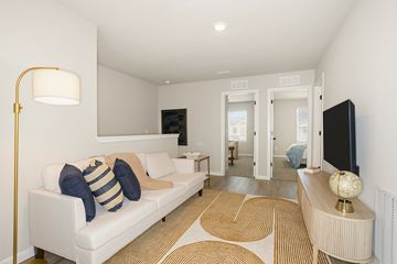 Middleburg apartment for rent - A living room with a white couch and a gold floor lamp.