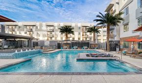 Phoenix apartment for rent - A large swimming pool in front of apartment buildings.