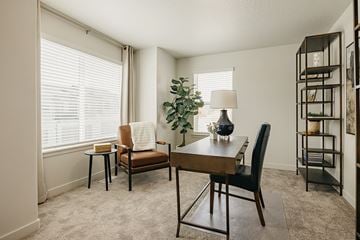 South Jordan townhouse for rent - A living room with a brown chair and a wooden table.