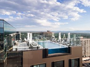 Denver apartment for rent - A glass building with a pool on the roof.