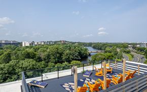 Boston apartment for rent - an outdoor deck with lounge chairs and a view of a river and trees