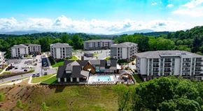 Asheville apartment for rent - A large building complex with a swimming pool in the foreground.