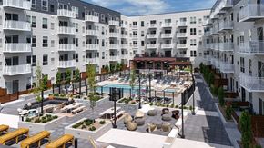 Hopkins apartment for rent - A large courtyard with a pool surrounded by apartment buildings at The Hallon apartments for rent in Hopkins, MN.
