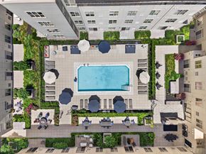 Hackensack apartment for rent - A pool surrounded by greenery in a courtyard.