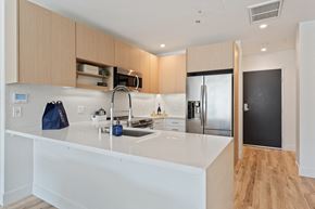 Oakland apartment for rent - a kitchen with a white counter top and a stainless steel refrigerator