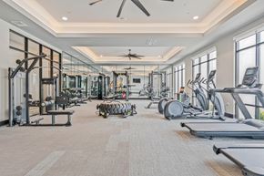 Denton apartment for rent - A spacious gym with a variety of equipment including treadmills, weights, and exercise machines.