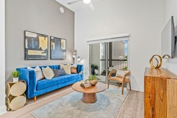 Denton apartment for rent - A living room with a blue couch and a coffee table.
