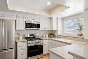 Aliso Viejo apartment for rent - A kitchen with white cabinets and stainless steel appliances.