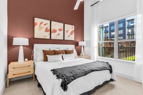 Allen apartment for rent - A bedroom with a large bed and a window overlooking a balcony.
