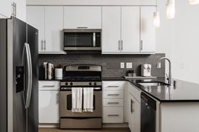 Marina Del Rey apartment for rent - A modern kitchen with a black refrigerator and white cabinets.