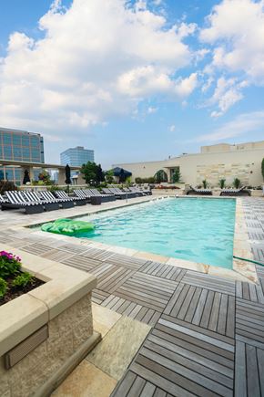 Charlotte apartment for rent - A pool surrounded by a tiled floor and a building in the background.