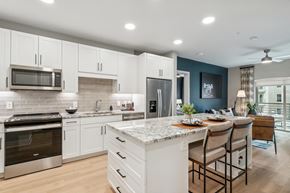 Dallas apartment for rent - a kitchen with white cabinets and a marble counter top