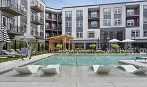 Marlborough apartment for rent - A pool area with a wooden structure in front of apartment buildings.