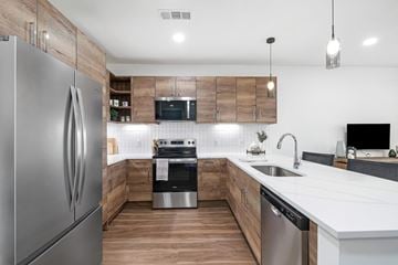 Mont Belvieu apartment for rent - A modern kitchen with a stainless steel refrigerator and wooden accents.