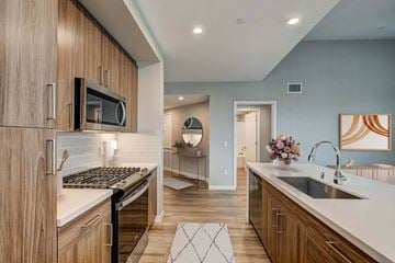 Morgan Hill apartment for rent - A modern kitchen with wooden cabinets and a black stove top.