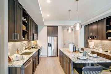 Tempe apartment for rent - A modern kitchen with dark wood cabinets and a marble countertop.