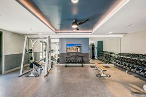 Tempe apartment for rent - A gym with a variety of equipment including weights and a bench.