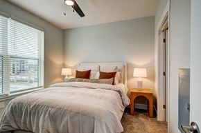 Baton Rouge apartment for rent - A bedroom with a large bed and a window with blinds.