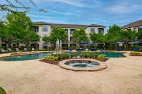 Baton Rouge apartment for rent - A large building with a pool and fountain in front.
