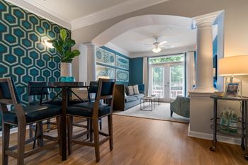 Model dining and living space with arched way and crown molding accents