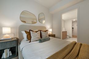 Washington apartment for rent - A bedroom with a large bed and two mirrors above it.
