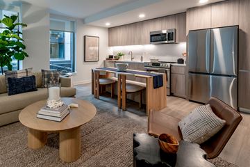 Washington apartment for rent - A modern kitchen and living room with a wooden coffee table in the center.
