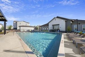 Georgetown apartment for rent - A large swimming pool with lounge chairs and a building in the background.