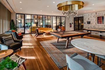 Washington apartment for rent - A modern living room with a pool table and a large chandelier.