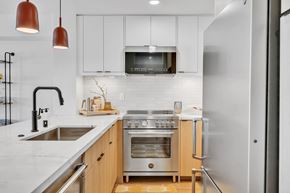 Newport Beach apartment for rent - A modern kitchen with a stainless steel refrigerator, a double oven, and a microwave above the stove.