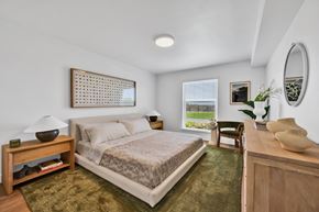 Newport Beach apartment for rent - A bedroom with a bed, nightstand, and a window with blinds.