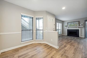 Charlotte apartment for rent - A spacious living room with a fireplace and a painting on the wall.