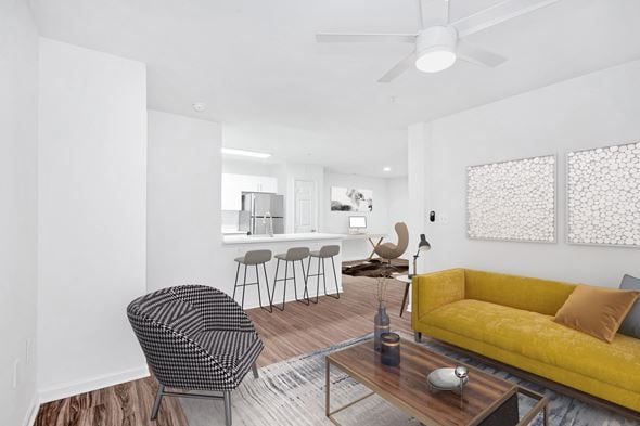 Manassas Park apartment for rent - a living room with a yellow couch and a table with chairs