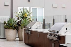 San Diego apartment for rent - A modern outdoor kitchen with a grill and potted plants.