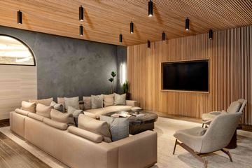 San Diego apartment for rent - A modern living room with a large couch and a flat screen TV mounted on the wall.