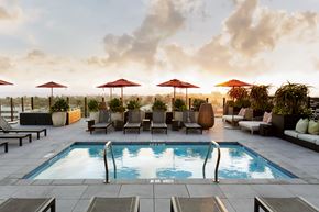 San Diego apartment for rent - A pool surrounded by chairs and umbrellas.