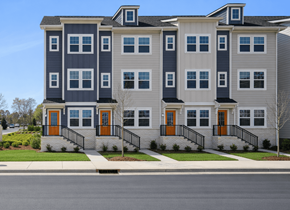 Charlotte townhouse for rent - A modern two-story apartment building with grey and white exterior and orange doors.
