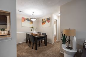 Memphis apartment for rent - A dining room with a table set for two and a lamp on a side table.
