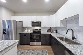 Huntsville apartment for rent - A modern kitchen with a stainless steel refrigerator and a microwave above the oven.