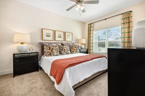Ladson apartment for rent - A bedroom with a bed, nightstand, and a ceiling fan.