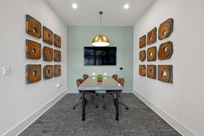Charlotte apartment for rent - A conference room with a table, chairs, and a wall of wood slices.
