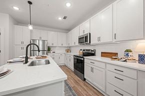 Mooresville apartment for rent - a large kitchen with white cabinets and black appliances