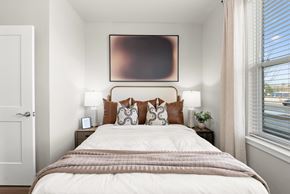 Charlotte apartment for rent - A bedroom with a large bed and a painting above it.