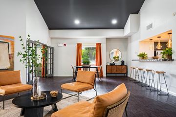 Albuquerque apartment for rent - A living room with orange chairs and a black table.