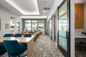 Charlotte apartment for rent - A conference room with blue chairs and glass walls.