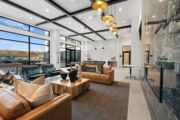 Charlotte apartment for rent - A modern living room with a brown leather couch and a wooden coffee table.