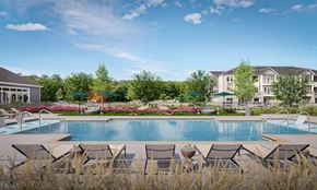 Charlotte apartment for rent - A pool surrounded by chairs and trees at Easton at Mountain Island new apartments in Charlotte.